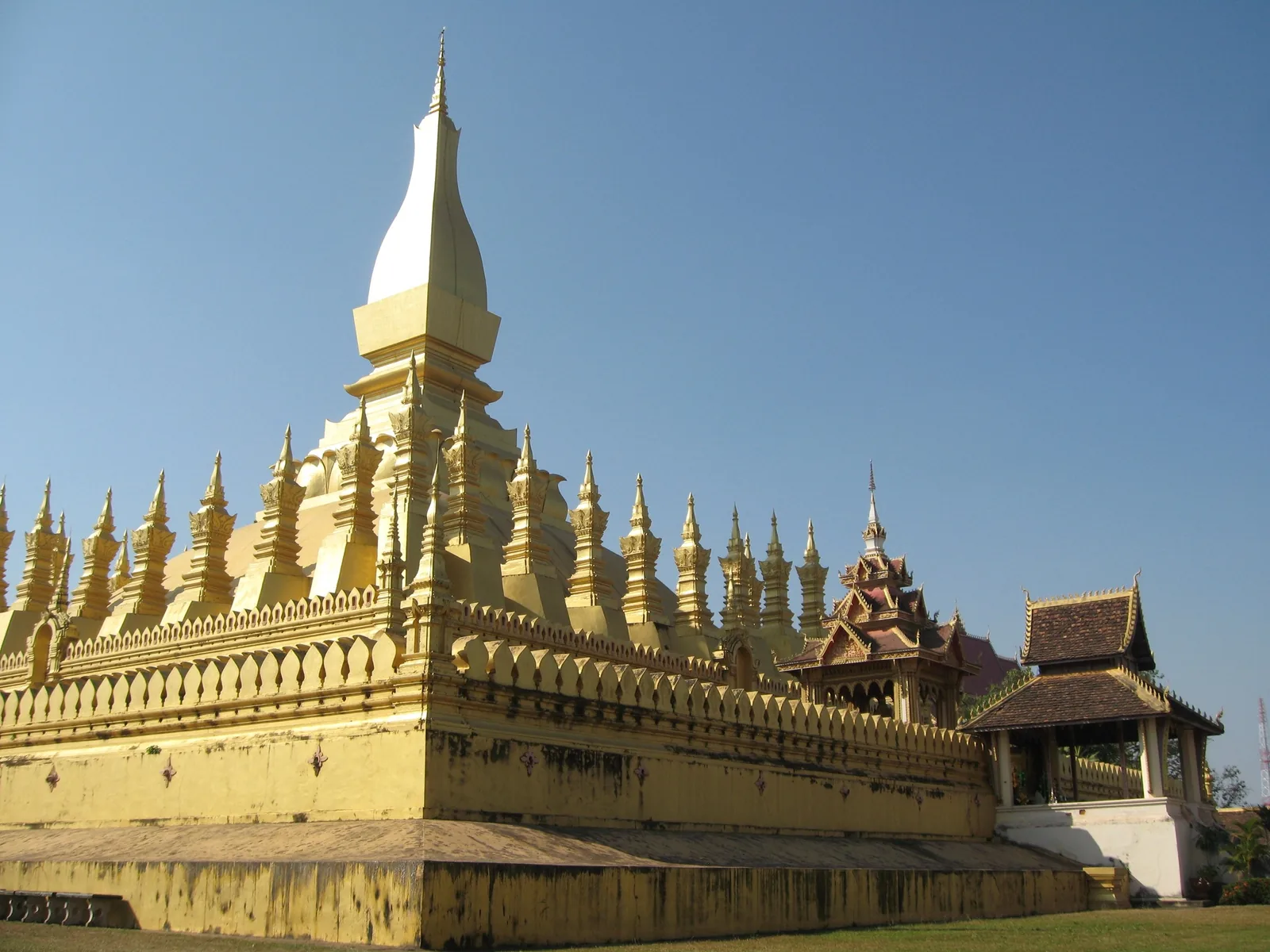 The golden stupa of Pha That Luang rises against a clear blue sky in Vientiane, Laos.