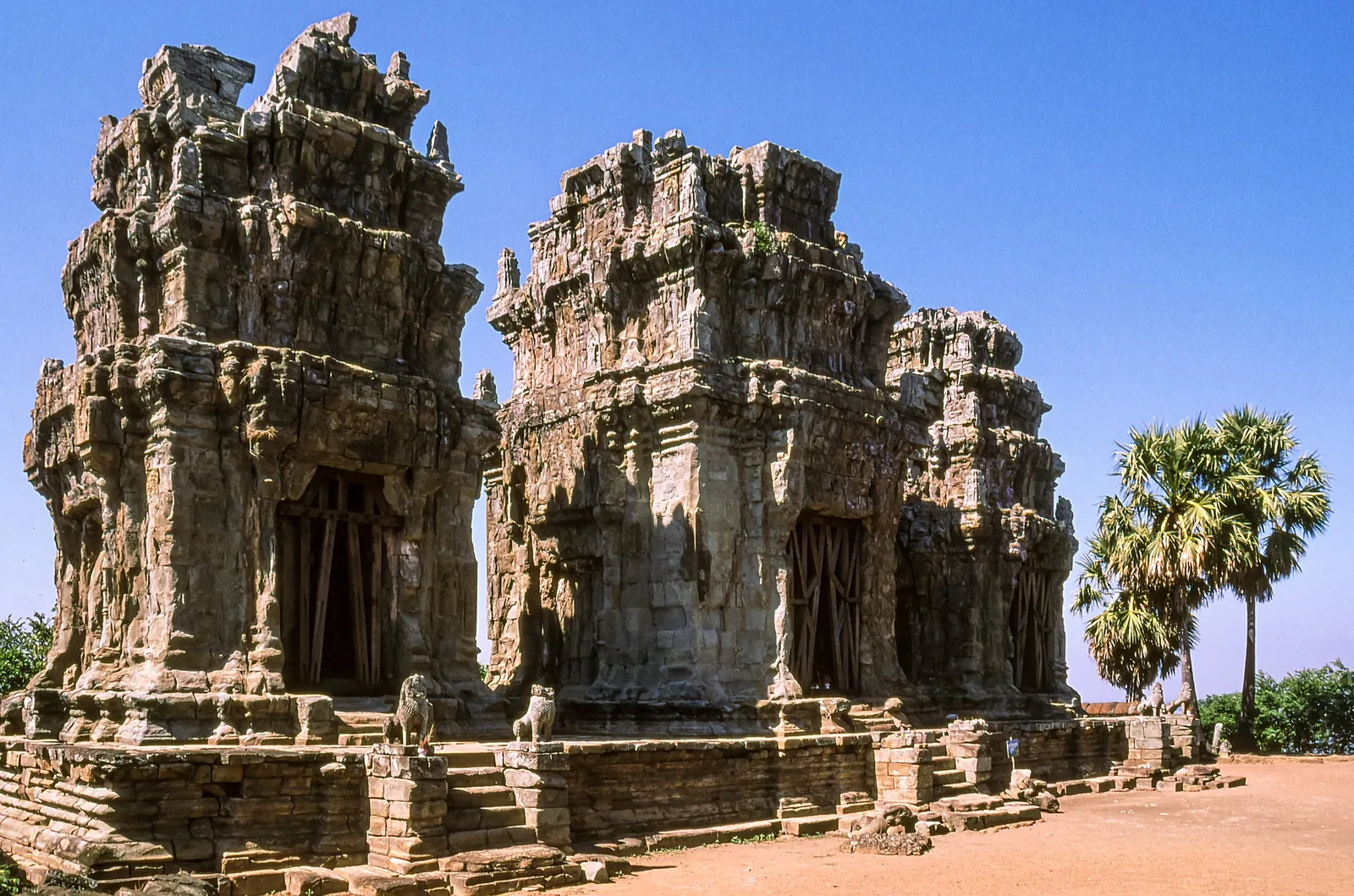 Ancient stone towers of Phnom Krom temple stand against a clear blue sky near Siem Reap.