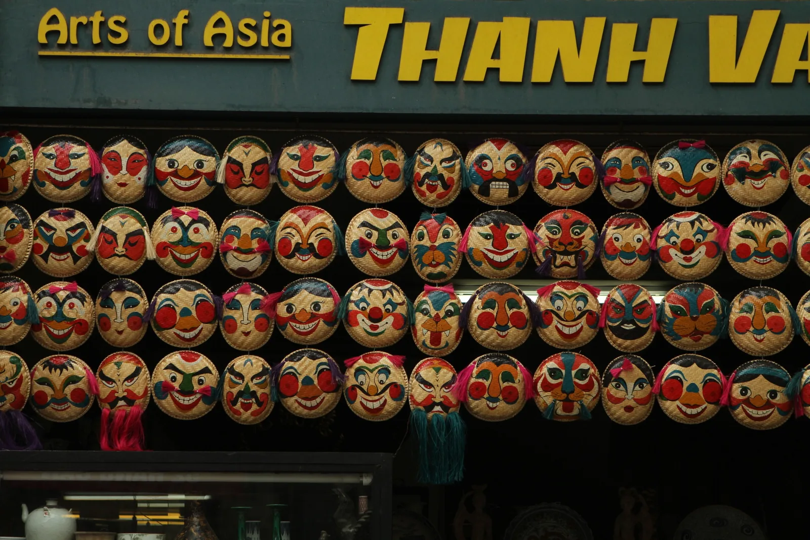 Rows of colorful hand-painted traditional masks hang for sale outside a shop in Hanoi.