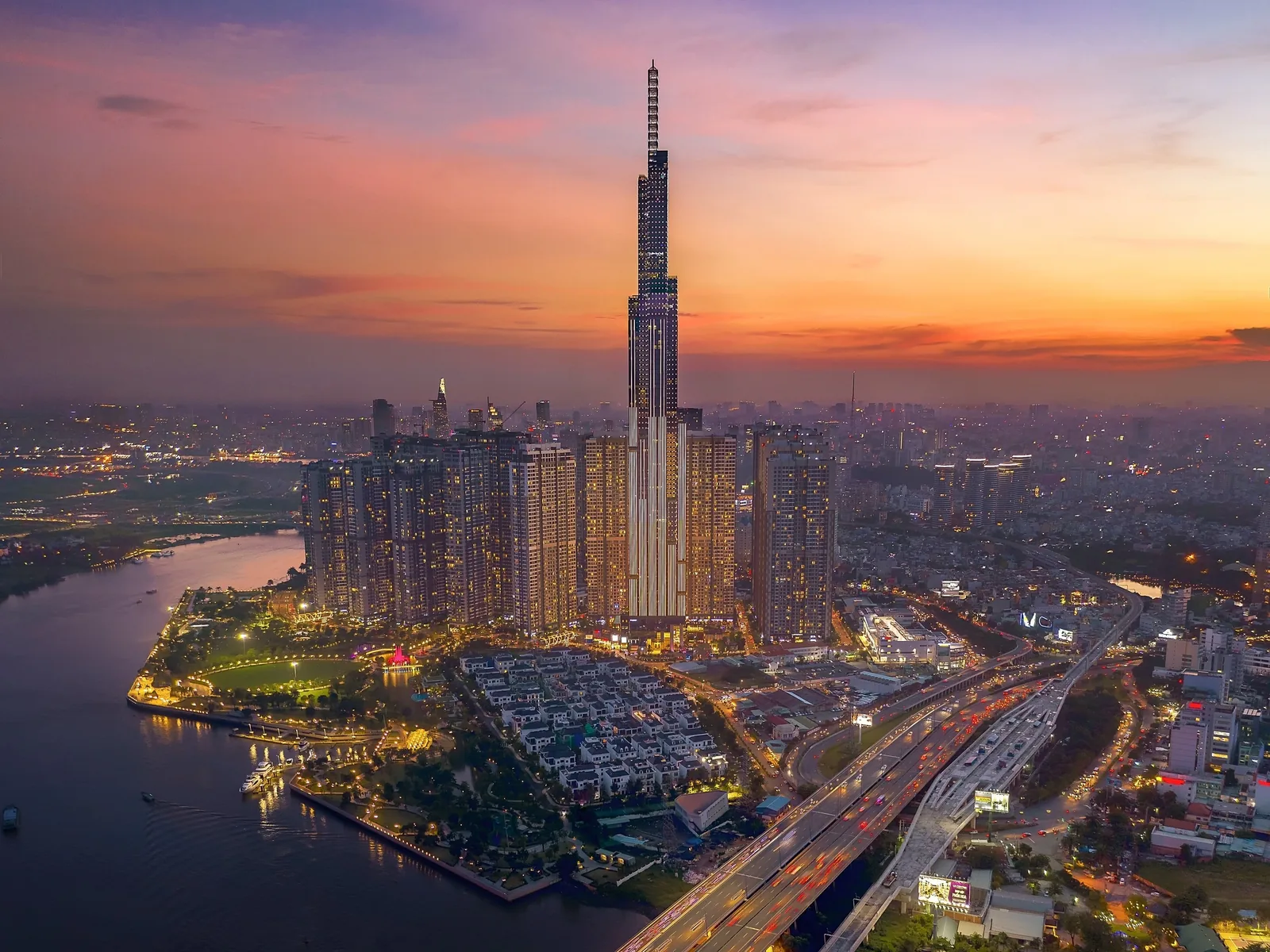 Aerial sunset view of Ho Chi Minh City skyline with the Landmark 81 tower rising above the Saigon River.