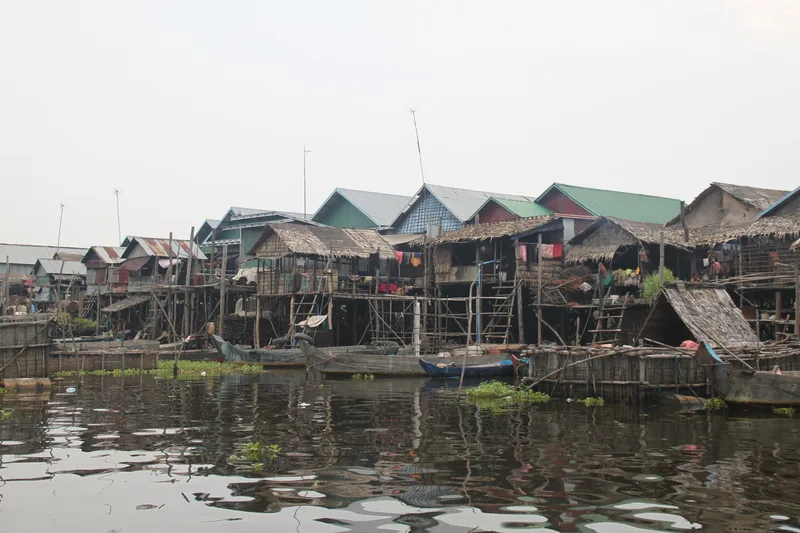 Stilt houses with wooden boats line the water at a floating village on Tonle Sap Lake near Siem Reap.