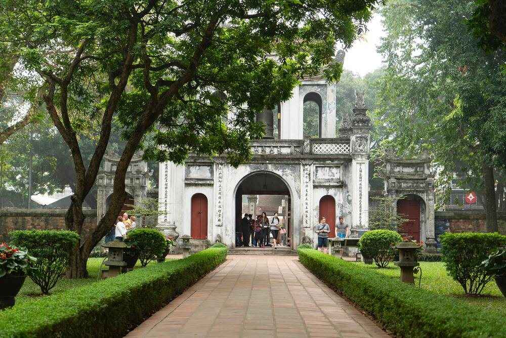 Old temple gateway at the end of a tree-lined avenue