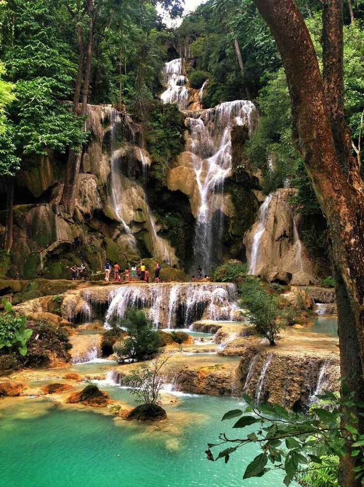 Turquoise pools stepping down through the forest at Kuang Si waterfall