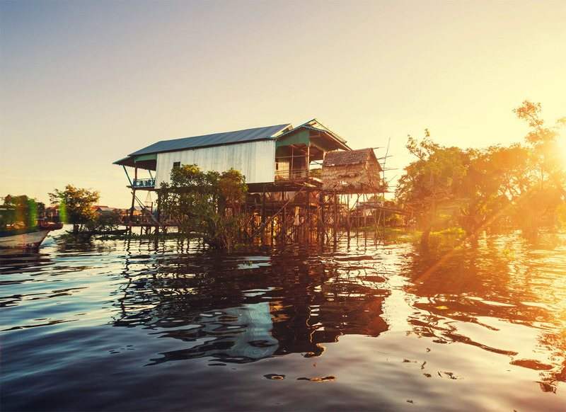 Stilt houses standing over the lake at sunset