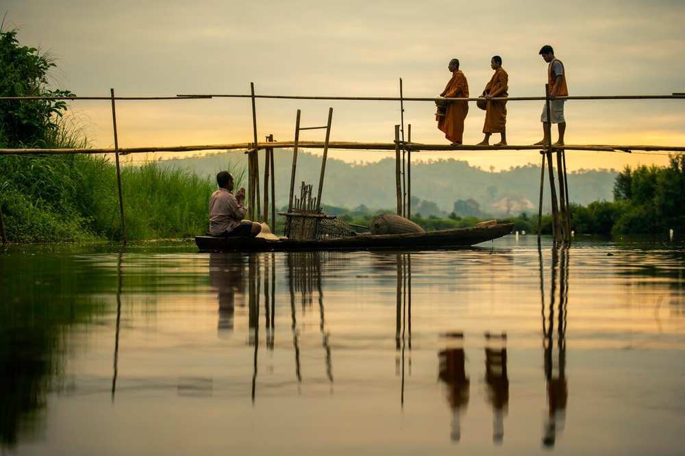 Fishermen working bamboo traps on the river at first light