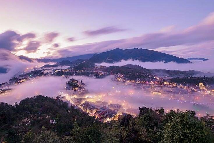 Hills and river valley glowing under a violet dusk sky